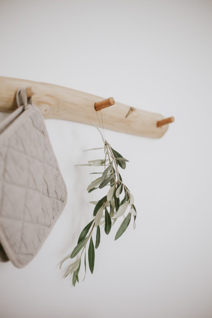 holzaufhänger mit olivenzweig und topflappen
